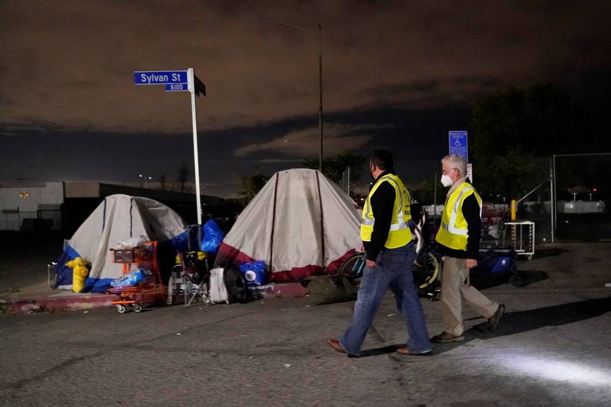 Los Angeles city councilmember Paul Krekorian, right, walks past tents where people are living ...