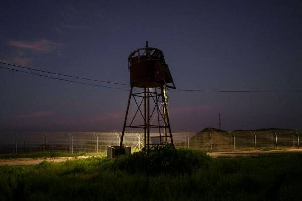 An old observation tower stands near the fence of Kibbutz Nahal Oz, Israel, Wednesday, Feb. 28, ...