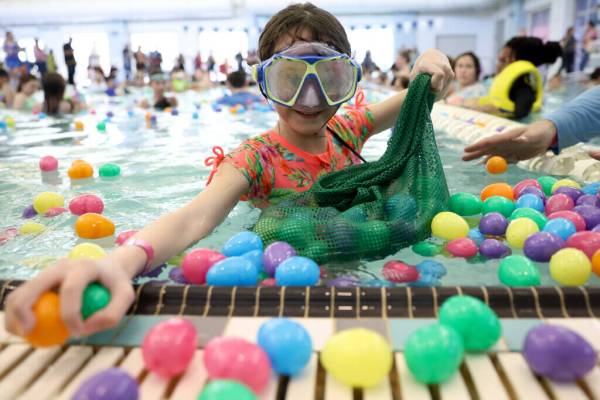 Isabella Rose, 10, fills her bag with loot during an Easter egg dive at Heritage Park Aquatic C ...