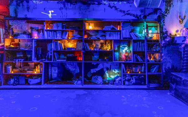 Animated characters and imagery are projected on the walls and bookcase in a scene at Particle ...