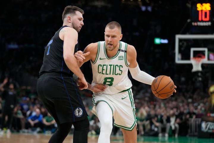 Boston Celtics center Kristaps Porzingis (8) drives against Dallas Mavericks guard Luka Doncic ...